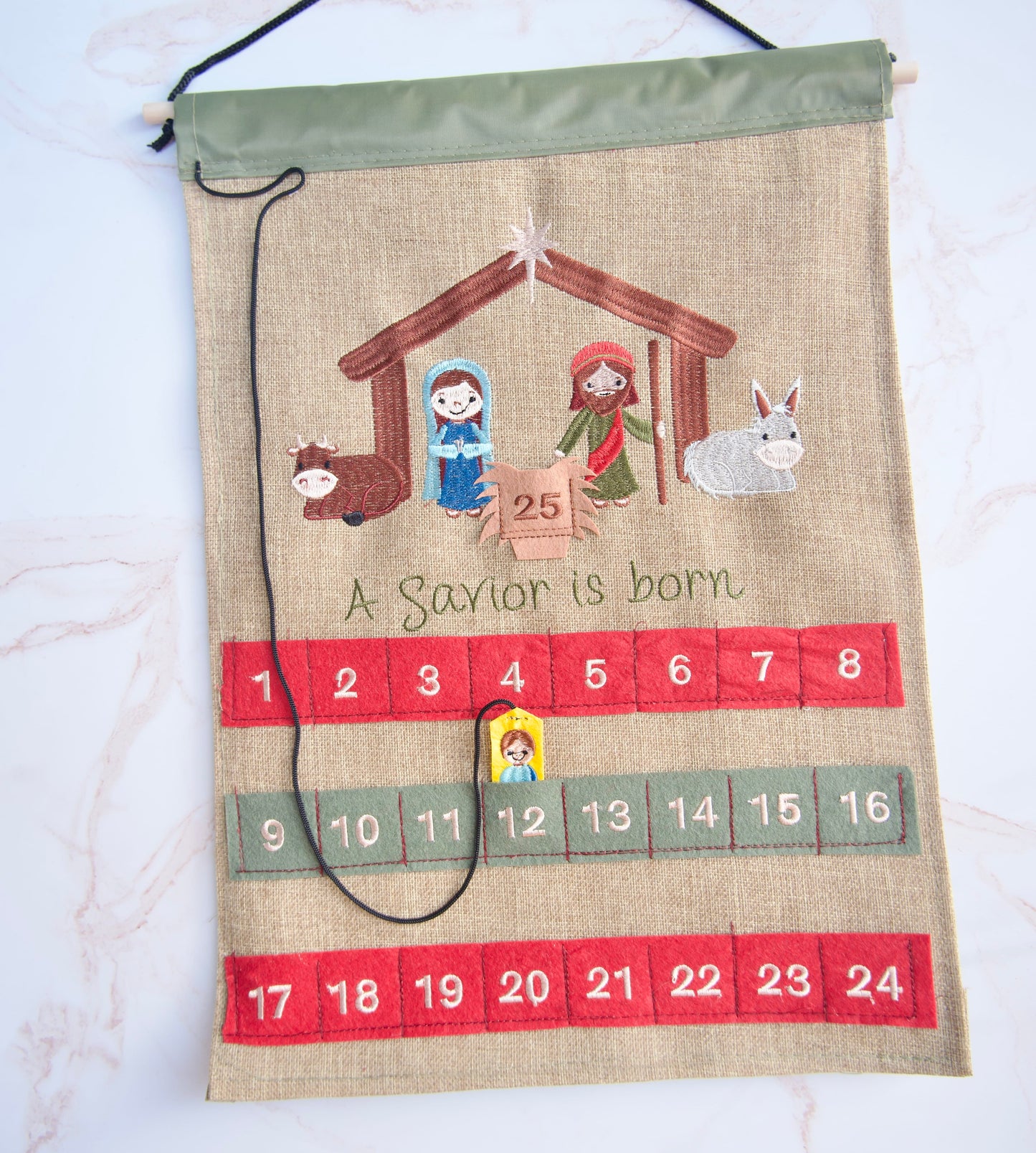Christian fabric Advent calendar showing Baby Jesus piece placed in the numbered pocket as children count down to Christmas