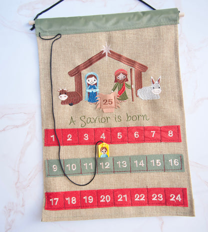 Christian fabric Advent calendar showing Baby Jesus piece placed in the numbered pocket as children count down to Christmas
